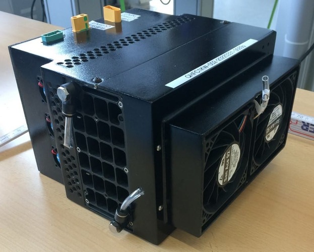 Black electronic device with cooling fans and vents, sitting on a wooden table. Black electronic device with cooling fans and vents, sitting on a wooden table.