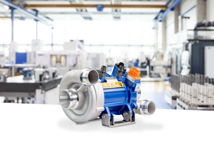 Blue industrial pump with metal fittings displayed on a white surface in a modern factory setting. Blue industrial pump with metal fittings displayed on a white surface in a modern factory setting.