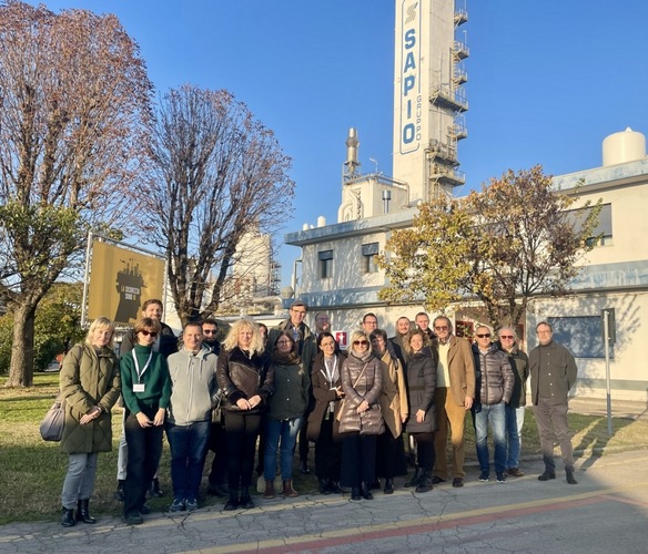 Group of people posing outside an industrial building with a sign that reads "SAPIO" on a sunny day. Group of people posing outside an industrial building with a sign that reads "SAPIO" on a sunny day.