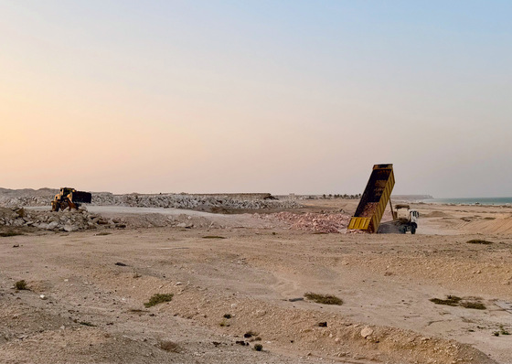 Earthworks in Duqm. The coastal desert resembles a lunar landscape. In the background, the Arabian Sea can be seen, which lies outside the Strait of Hormuz.